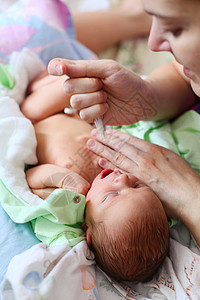母亲用注射器喂养新生儿婴儿奶父母重量育儿说谎哺乳期女性保健微笑男性牛奶图片