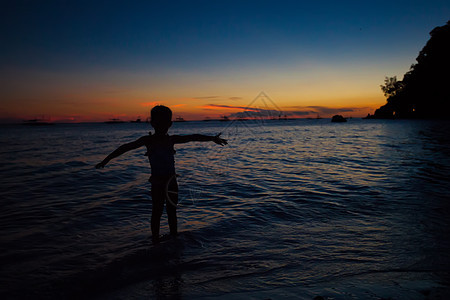 菲律宾博拉凯岛日落时小女孩的轮椅 菲律宾Boracay岛橙子蓝色海滩假期娱乐女儿太阳热带婴儿异国图片