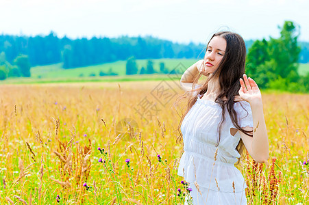 俄罗斯美丽的女人在田野 花朵的俄罗斯美女背景图片