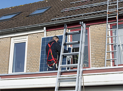 男人用太阳能电池板攀登梯子安装控制板光伏环境工具安全力量衣领住宅工人图片