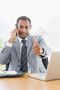 在待命时微笑的商务人士举起拇指职业技术职场办公室电脑笔记本电话套装混血日记图片