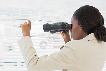 商业妇女透过百叶窗用望远镜偷窥商务工作套装女士人士女性黑发公司办公室头发图片