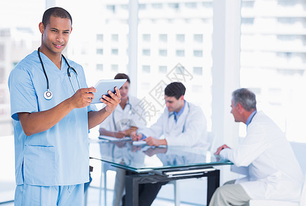 使用数字平板电脑 在医院的桌子周围组群进行外科手术专家医疗保健会议团队药片工人卫生同事女士办公室图片