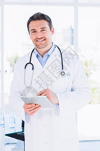 使用数字平板电脑对一名男医生的肖像工作男人药片医院滚动职业医疗触摸屏医务室从业者图片