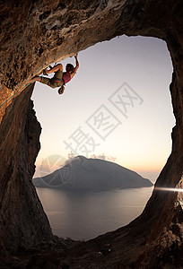 希腊卡利姆诺斯日落时女性攀岩者图片