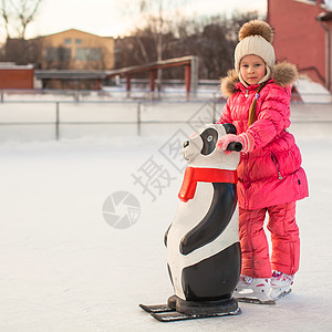快乐的小女孩滑冰在冰上溜冰者微笑喜悦小姑娘溜冰场学习孩子生活方式童年企鹅图片