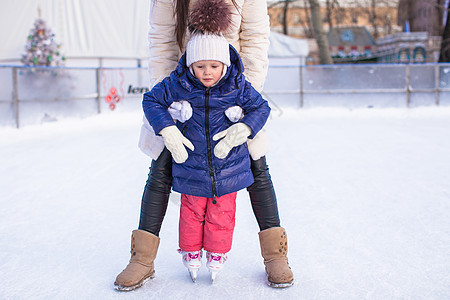 快乐可爱的小女孩和年轻母亲 学习滑冰训练乐趣教学童年女儿娱乐小姑娘闲暇锻炼孩子图片