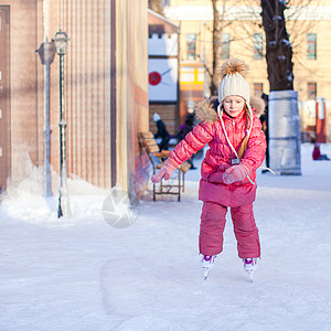 可爱快乐的小女孩 享受滑冰在冰场冰鞋学习套装城市生活方式小姑娘女儿速度童年运动图片
