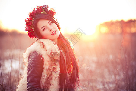 穿毛皮背心的年轻妇女化妆品帽子幸福橙子女性微笑头发女士草地太阳图片