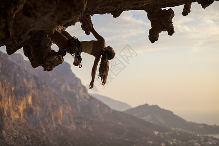 日落时女性攀岩者运动天空太阳女士悬崖女孩绳索洞穴风景登山者图片