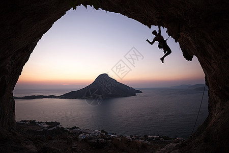 日落时的攀岩者登山者洞穴男人挑战绳索高度岩石悬崖男性运动图片