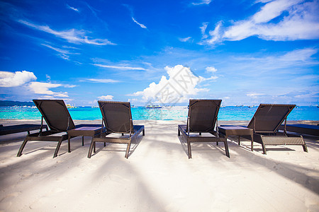 在完美的白沙滩上 奇异度假村的海滩椅子天空情调假期海岸线异国躺椅天堂海洋旅行日光浴图片