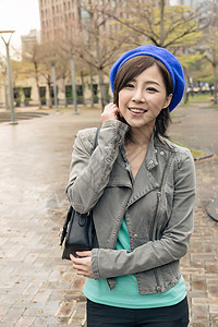 亚洲妇女在街上行走欢呼女士微笑帽子女性公园喜悦下雨魅力图片