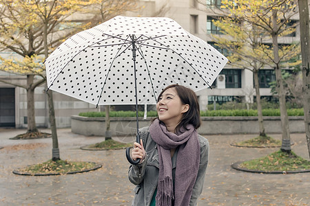 带着伞的笑笑快乐的亚洲妇女乐趣魅力喜悦女士街道下雨女性图片