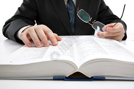 人在字典里寻找信息词本眼镜阅读手表手指工作男人词汇表商业桌面图片