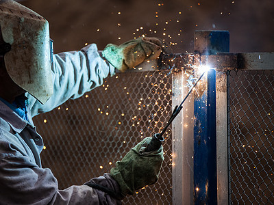 保护面罩焊接金属结构中的焊接焊机工人男人技术职业建造工程金工火焰生产工具力量图片