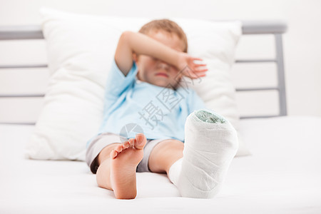 小男孩 腿脚跟骨折或br上贴着石膏绷带的幼小男孩男人脚跟身体医院赤脚卫生男生保健治疗保险图片