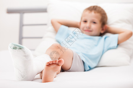 小男孩 腿脚跟骨折或br上贴着石膏绷带的幼小男孩孩子赤脚男性男生疼痛解剖学科学卫生青少年保险图片