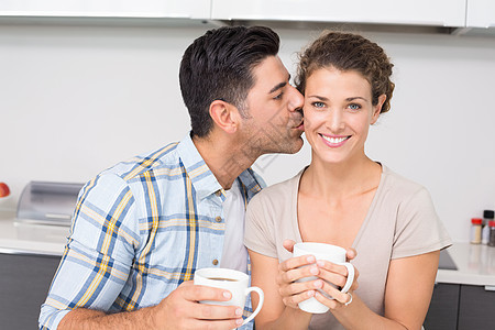 喝着咖啡的开心女人 得到伴侣的亲吻图片