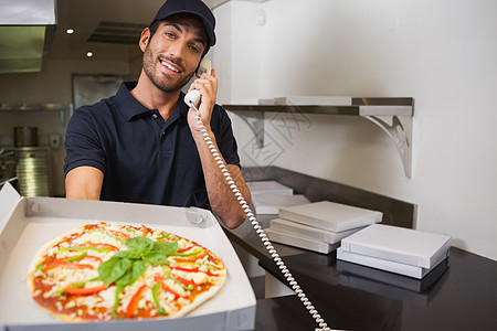 笑面披萨快递员 在电话上下订单 显示比萨饼图片