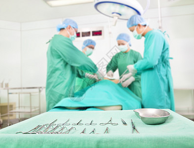 在手术室工作的小组外科医生 一个配有工具的桌子图片