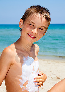 使用防晒霜的男孩皮肤晴天阳光洗剂护理太阳日光浴棕褐色身体游泳衣图片