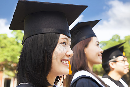 与同学站在一起的女大学生毕业时笑着微笑的女大学生图片