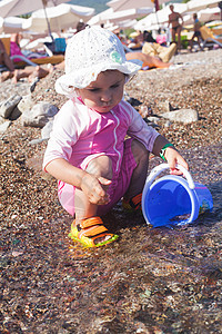 海上的婴儿游戏女孩海岸假期孩子们玩具海滩废墟童年支撑孩子图片