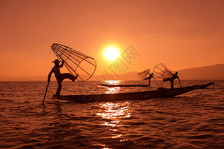 缅甸按网捕捞的传统渔网橙子文化平衡独木舟入口热带男人反射日落渔民图片