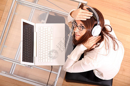拥有笔记本电脑和耳机的妇女工人女士展示办公室技术拉丁助手键盘娱乐监视器图片