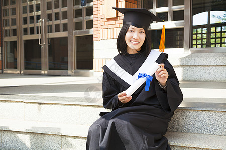 亚裔大学生在校园持有毕业文凭图片