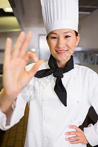 微笑的女性烹饪 在厨房里签好字职业手势女士帽子餐厅制服工作沟通厨师白人图片