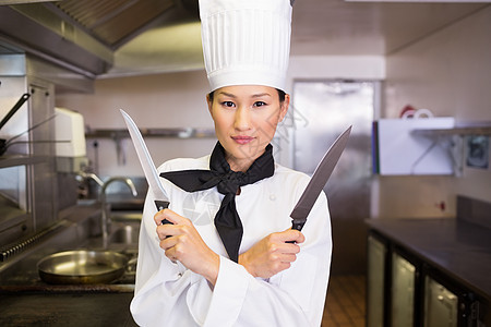 自信的女厨师在厨房里拿着刀子餐厅女士女性制服工作职业白人刀具帽子图片