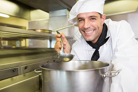 微笑的男性在厨房煮饭食物烹饪职业男人帽子工作制服厨师勺子餐厅图片
