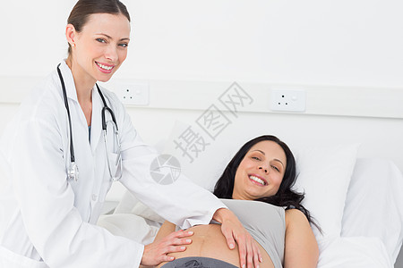 孕妇和医生美貌美丽的检查孕妇的医生背景