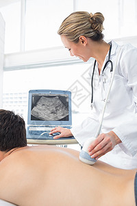 男性病人背部使用声波图的医生图片