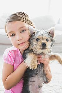 小女孩抱着她的日新月小狗图片