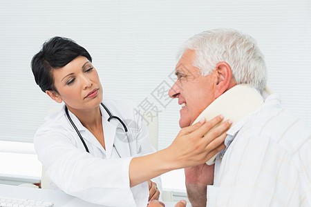 女医生检查一名老年病人颈部理疗退休疼痛黑发男人从业者医务室混血办公室保健图片