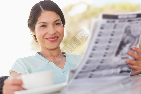 拥有咖啡和阅读报纸的女商界人士咖啡店快乐女性阳台闲暇混血微笑头发桌子露台图片