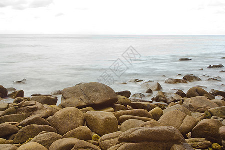 长期接触海洋和岩石日落假期乳白色场景天空波纹石头海浪海景运动图片