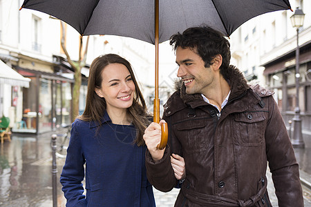 街上雨下一对英俊的情侣季节性白色男人男性城市微笑下雨季节女性夹克图片