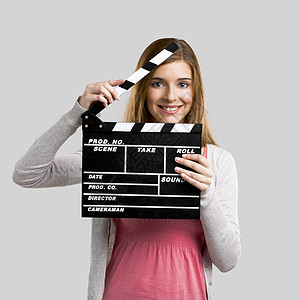 美丽的女孩拿着掌拍盘隔板学生演员行动制作人粉笔青年黑板电影相机图片