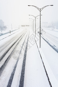 公路上的日落光和暴雪扰乱暴风雪运输车辆危险季节旅行阳光雪花降雪天气图片