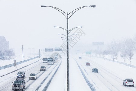 暴风雪期间的对称公路照片运输雪花季节路线中位数中心风暴交通车辆状况图片