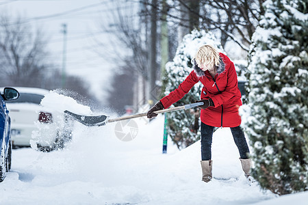 妇女冲洗她的停车场季节风暴暴风雪薄片打扫降雪乐趣雪花街道城市图片