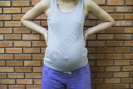 妇女在砖墙前的孕妇形象图片