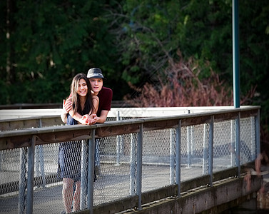 年轻的跨种族夫妇站在水上桥上的桥梁上图片