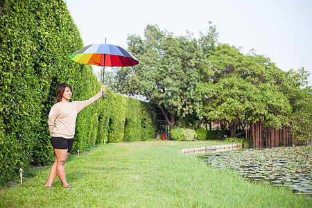 在公园里拿着伞的亚洲女人成人喜悦森林幸福季节街道裙子叶子女士天气图片