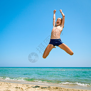 男孩在海滩上跳跃娱乐闲暇活力孩子享受活动晴天调子游泳衣游戏图片