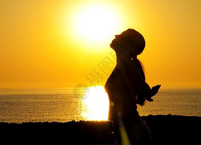 太阳下阴暗的彩色月光祷告上帝海洋生态自由女性女孩日落宗教活力图片